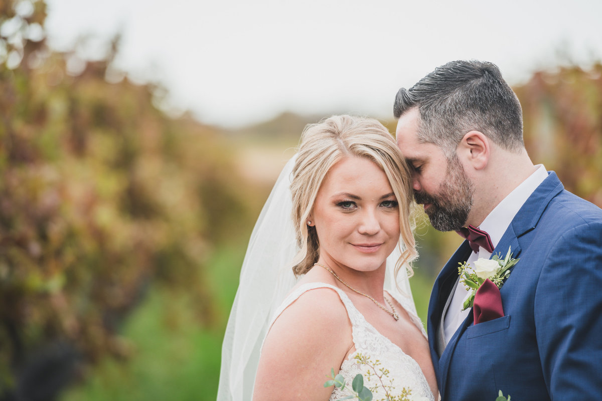 wedding photo of bride and groom with vineyards blurred out at The Vineyards at Aquebogue