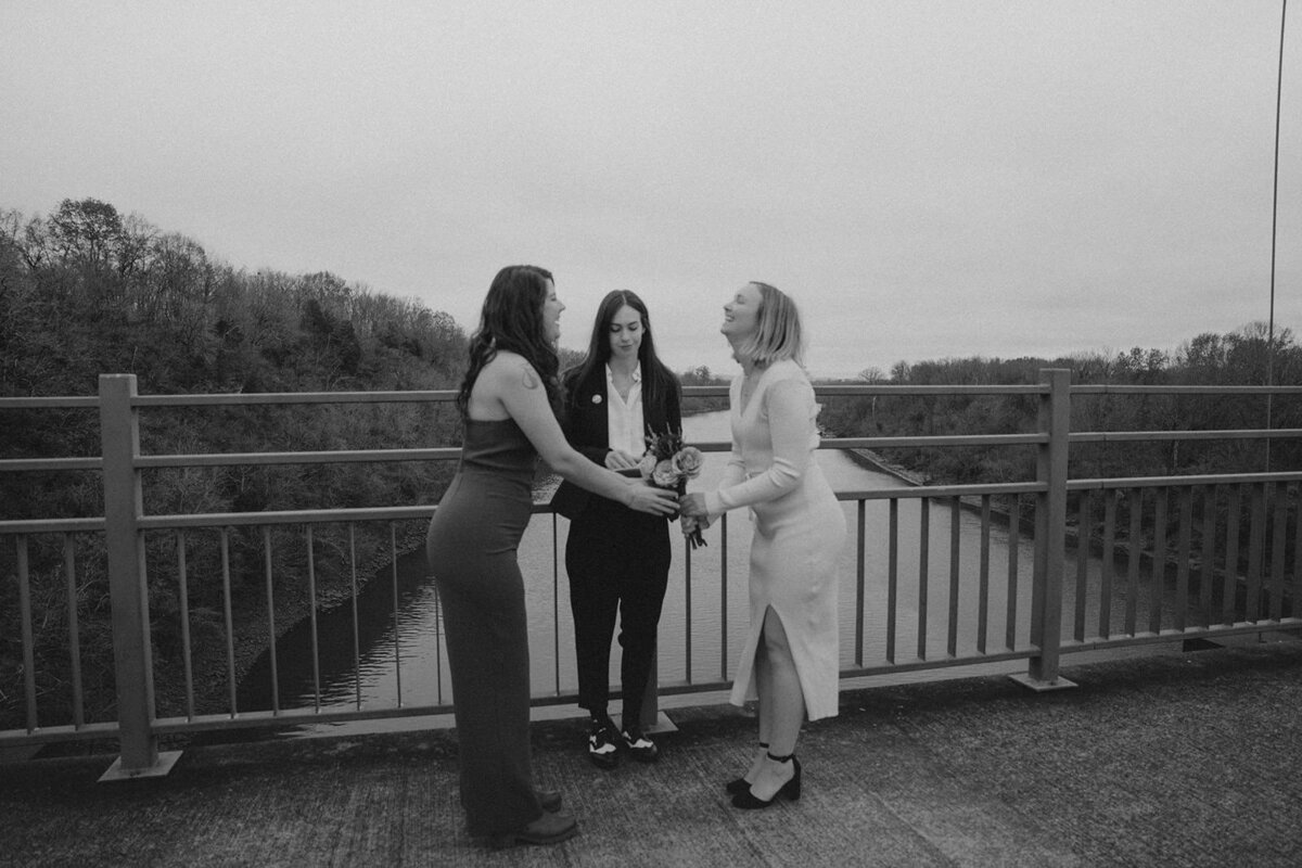 Two wives and their officiant stand on a Nashville bridge for their Tennessee elopement