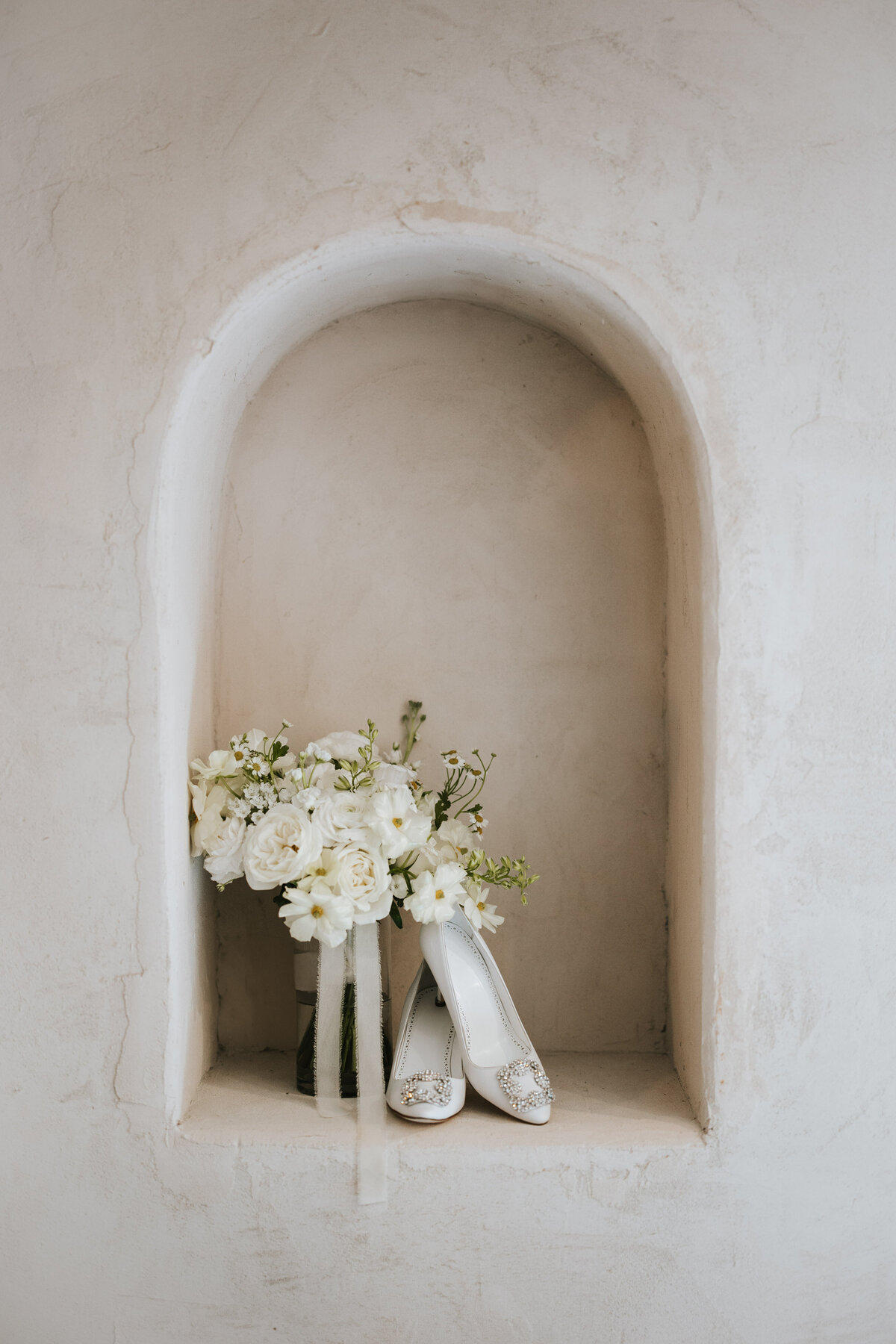 Close-up of the bride’s shoes and bouquet, captured with delicate detail.
