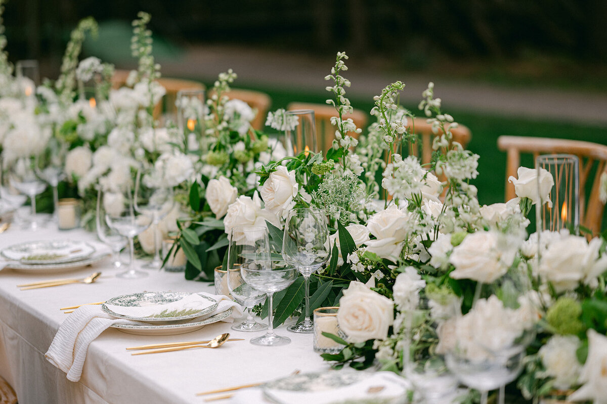 Outdoor Wedding Reception Dinner Table with Lush green and white florals.