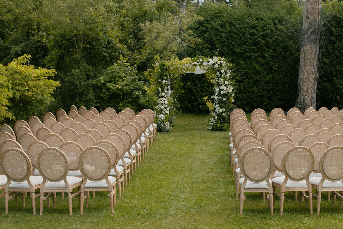 A view of the aisle at the Willow Inn, featuring a chuppah of white flowers and lush greenery.
