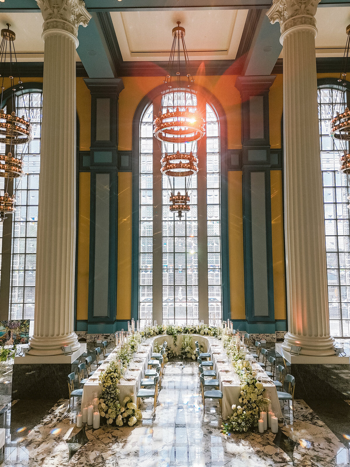 White wedding with blue chairs and gold accents with greenery