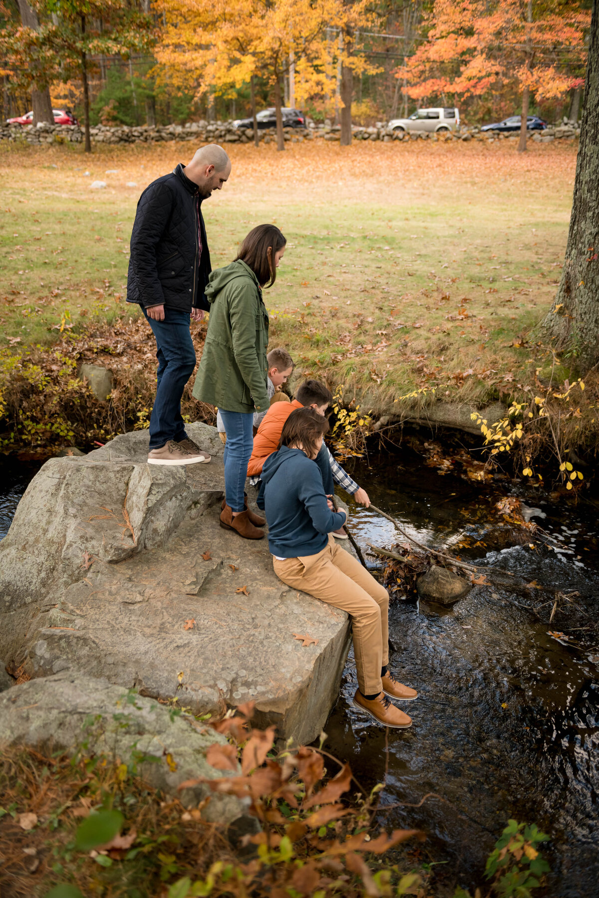 family sitting on a rock in a stream