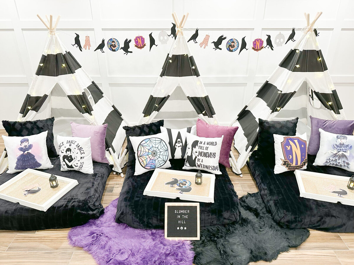three teepee beds with Wednesday Addams pillows and props