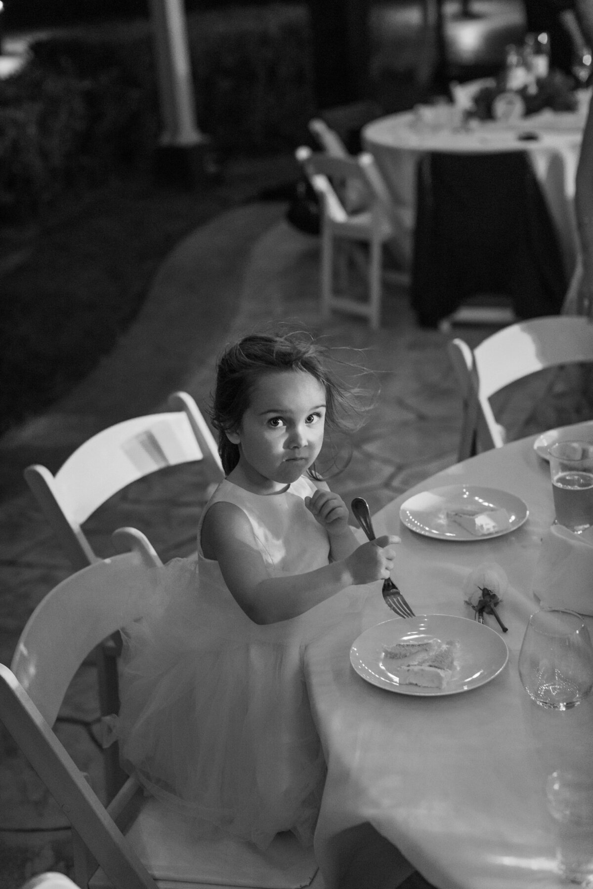 Young flower girl enjoys cake at the reception during a Cancun wedding, photographed by Philly-based photographer.