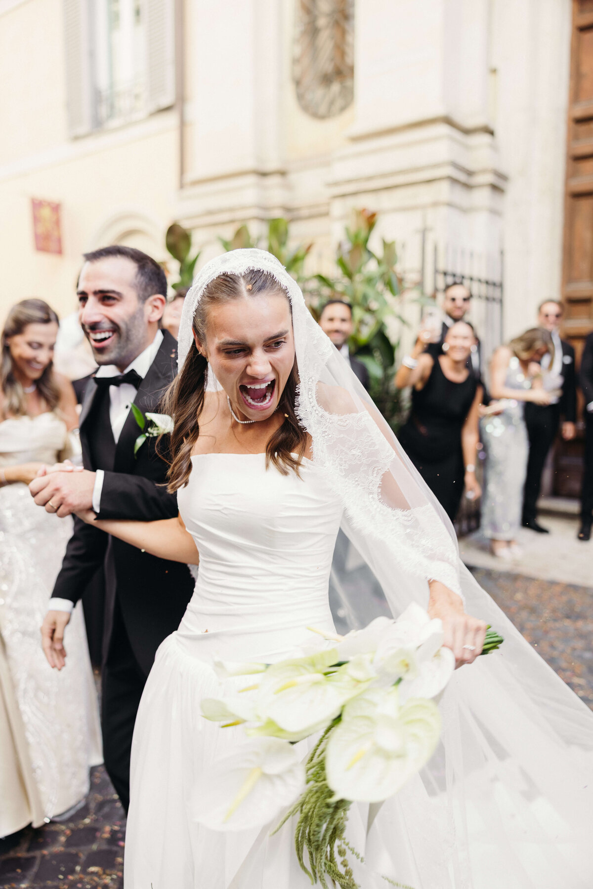 Bride and groom walking through cheering crowd after saying “I do”

