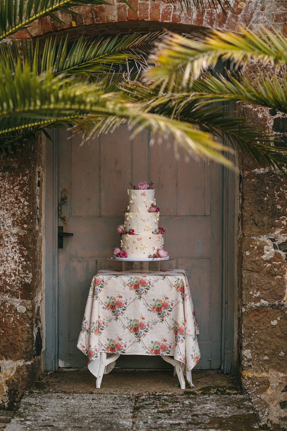 Outdoor Wedding cake with palms at Trelowarren Estate in Cornwall
