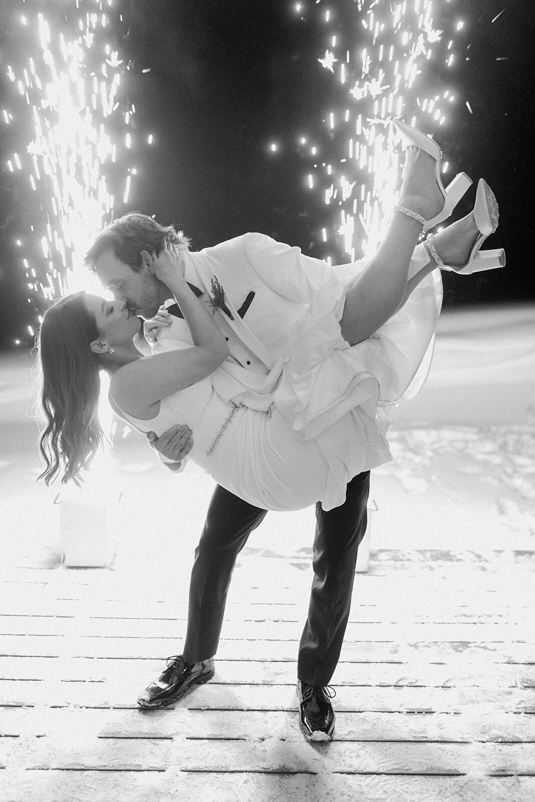 Couple's first dance during wedding reception with sparklers in background, captured by Nikki Collette, featured on the Brontë Bride Wedding Vendor Guide.