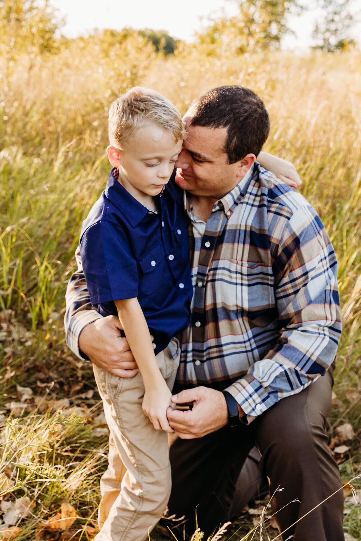 Dad resting his head against his son's during family photo session with Ashley Kalbus Photography