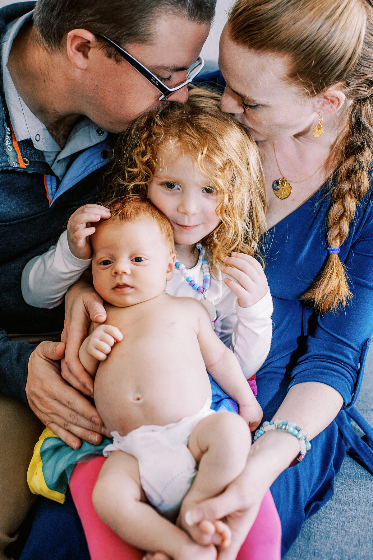 four family members snuggle during newborn photo session