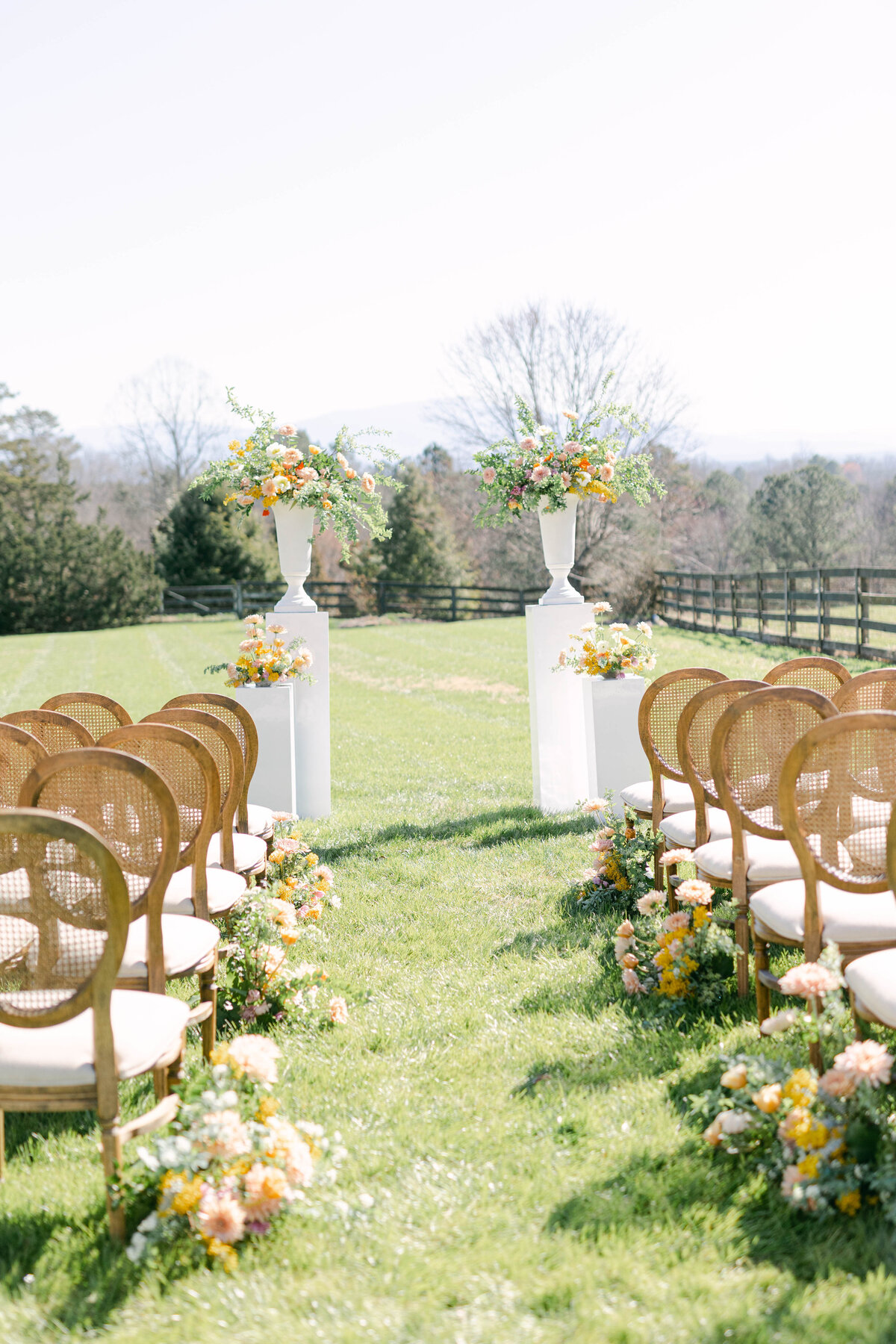 GA wedding ceremony bright florals on white podiums and french inspired chairs