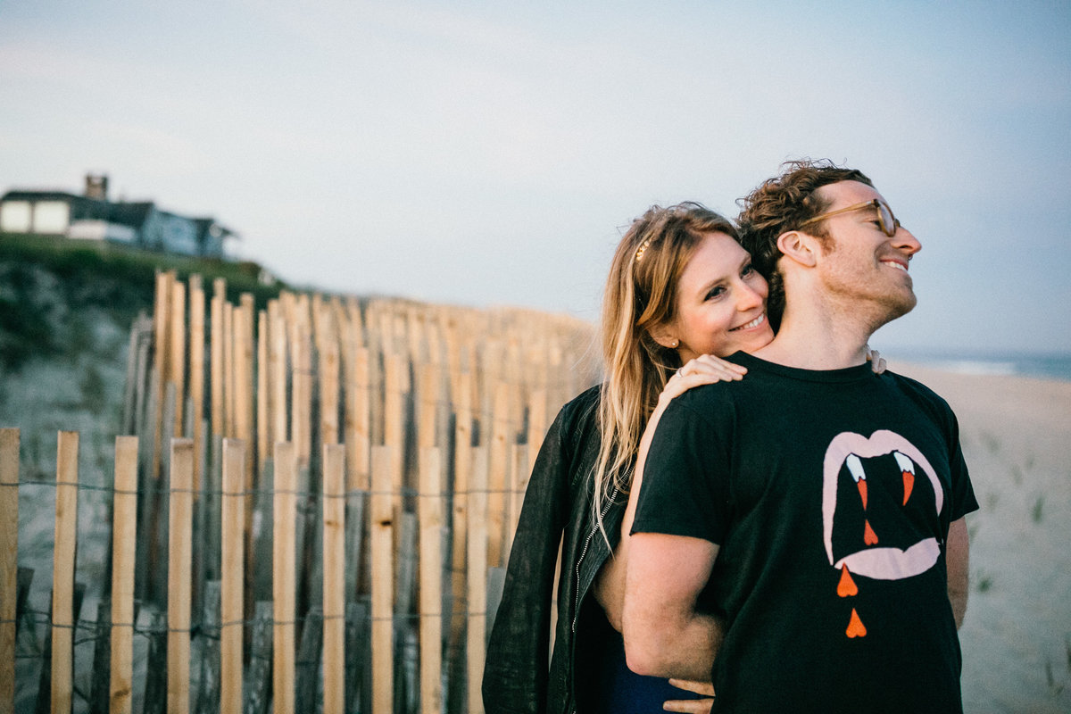 Soon to be bride cuddled up to her man during there sunset beach engagement session.