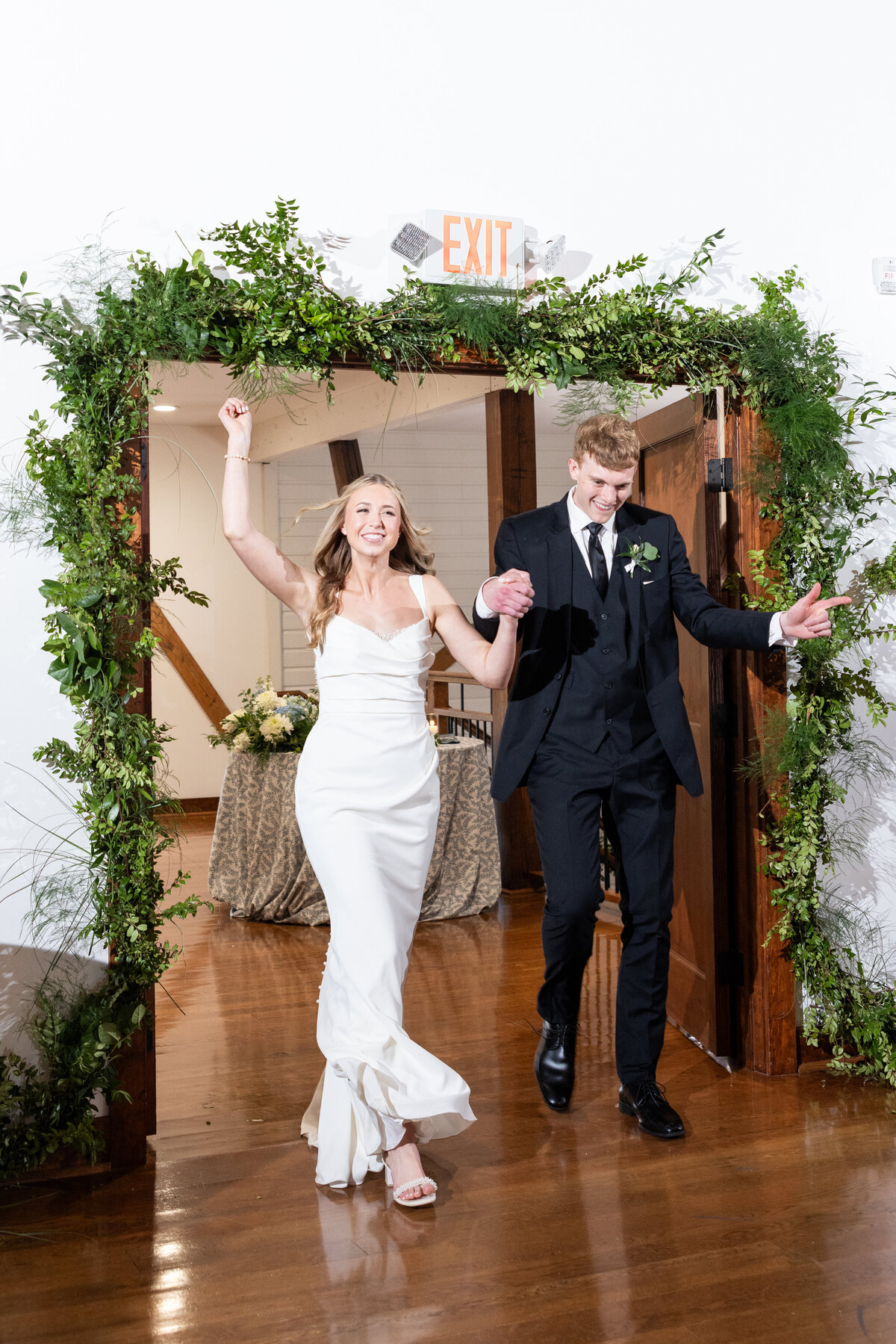 Spring wedding at WinMock at Kinderton, designed by Charming Carolina — bride and groom entering the Loft reception as husband and wife to cheers from guests.
