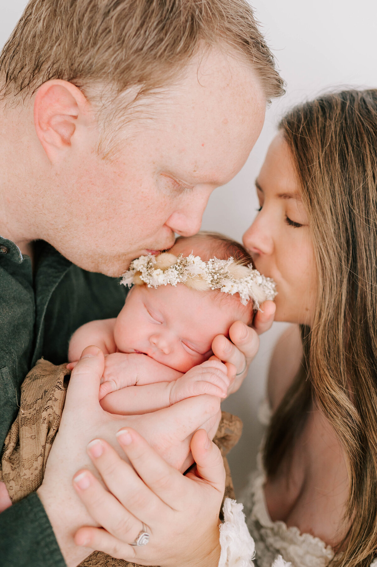 newborn photo in Springfield MO of parents kissing baby girl