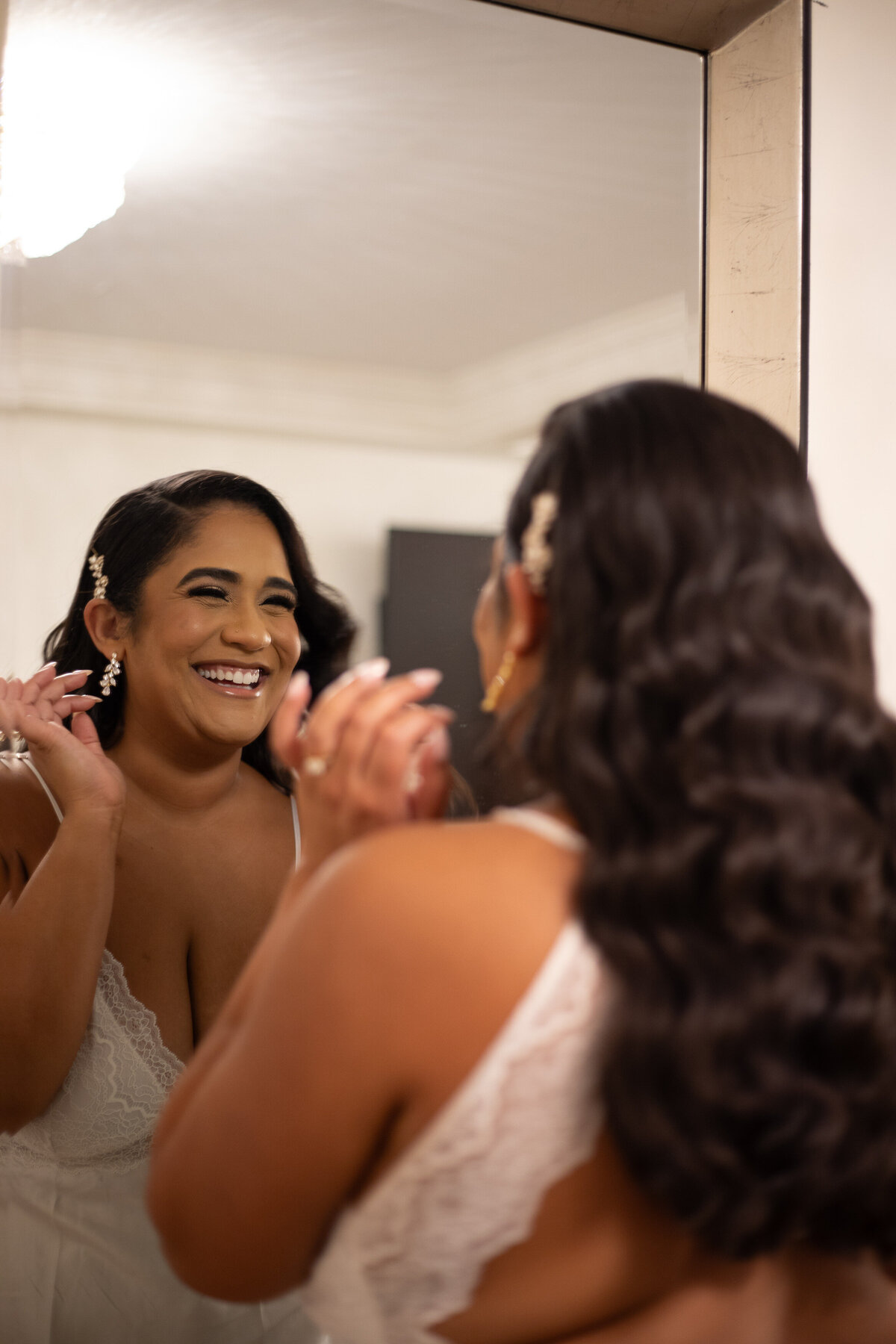 Bride smiling at her reflection in the mirror