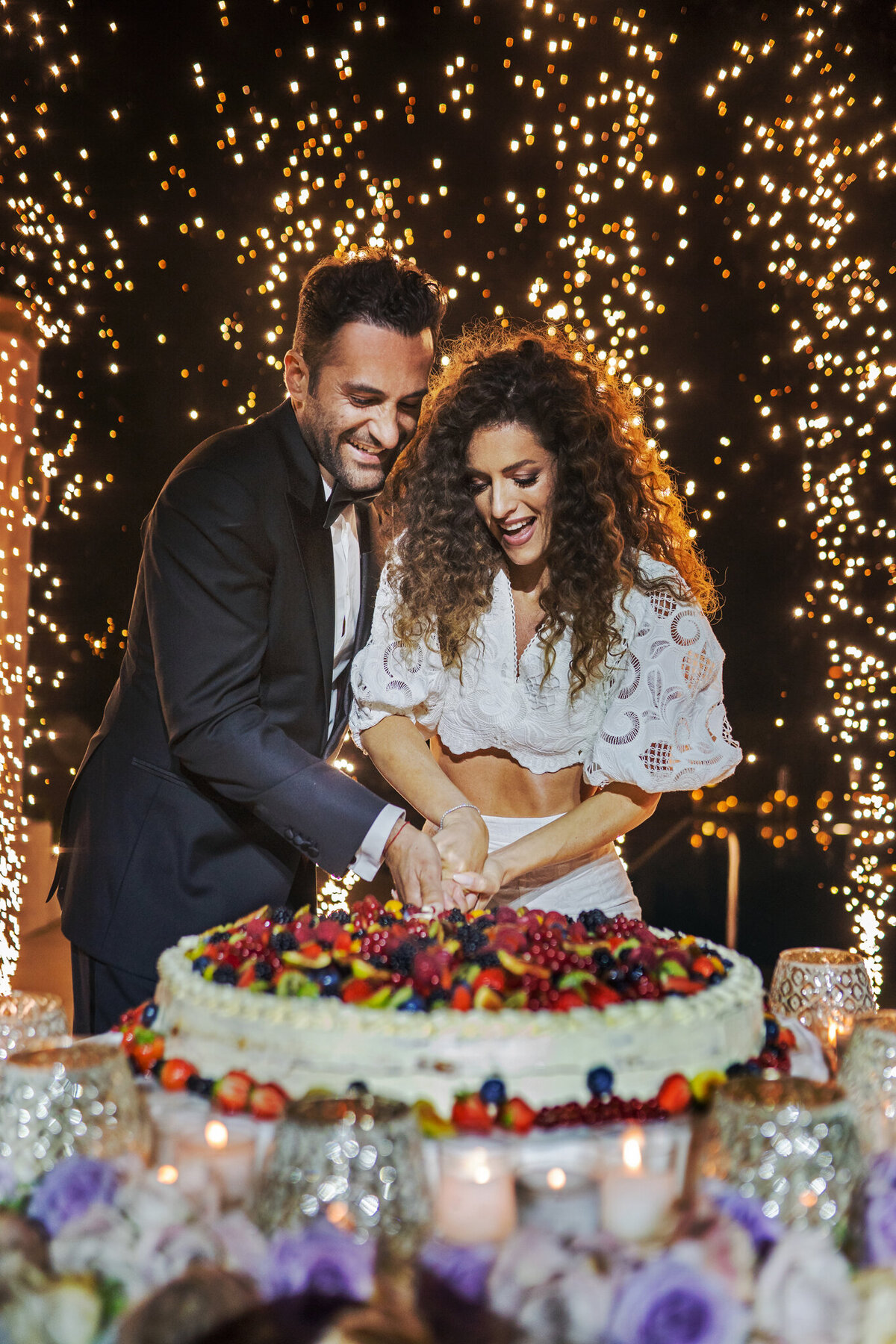 Cake cutting moment with wedding fireworks