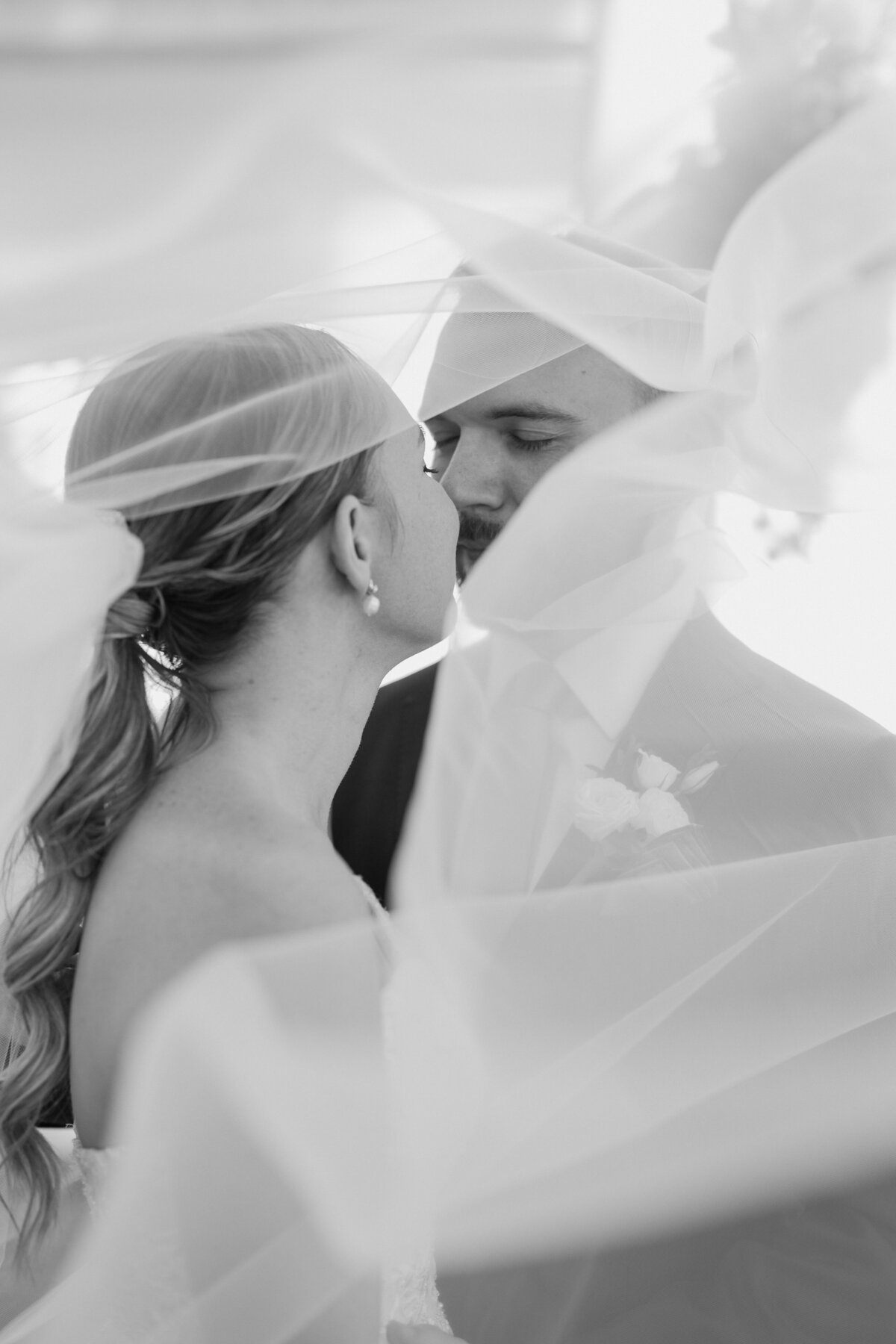 A classic black and white veiled picture of a couple under the veil. 