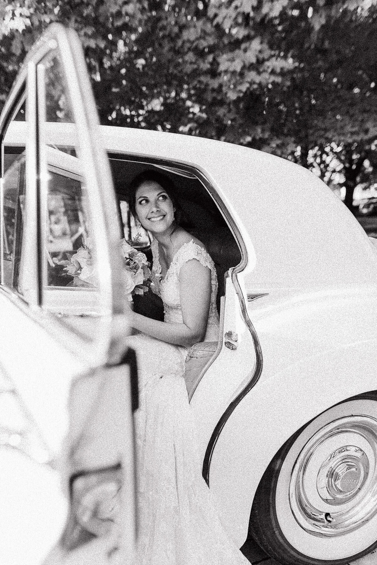 Une mariée dans une voiture d'époque, image en noir et blanc. 