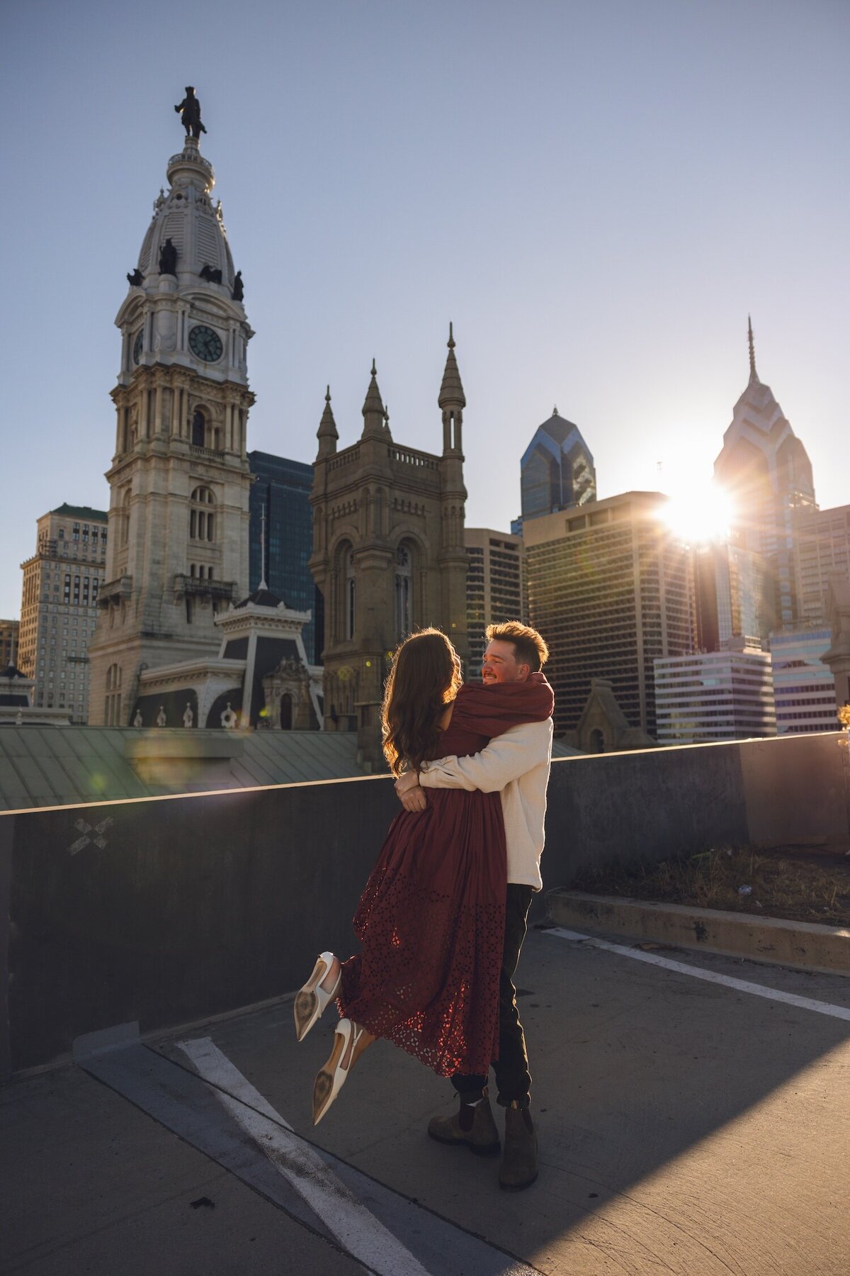 Groom lifting fiancée off the ground for a playful spin.