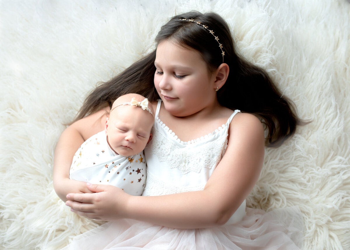 sisters snuggle for picture in studio photography session in Colorado