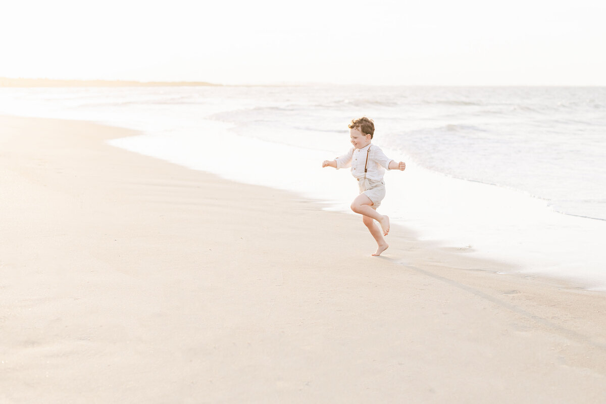 a little boy skipping alond the Destin beach shoreline.