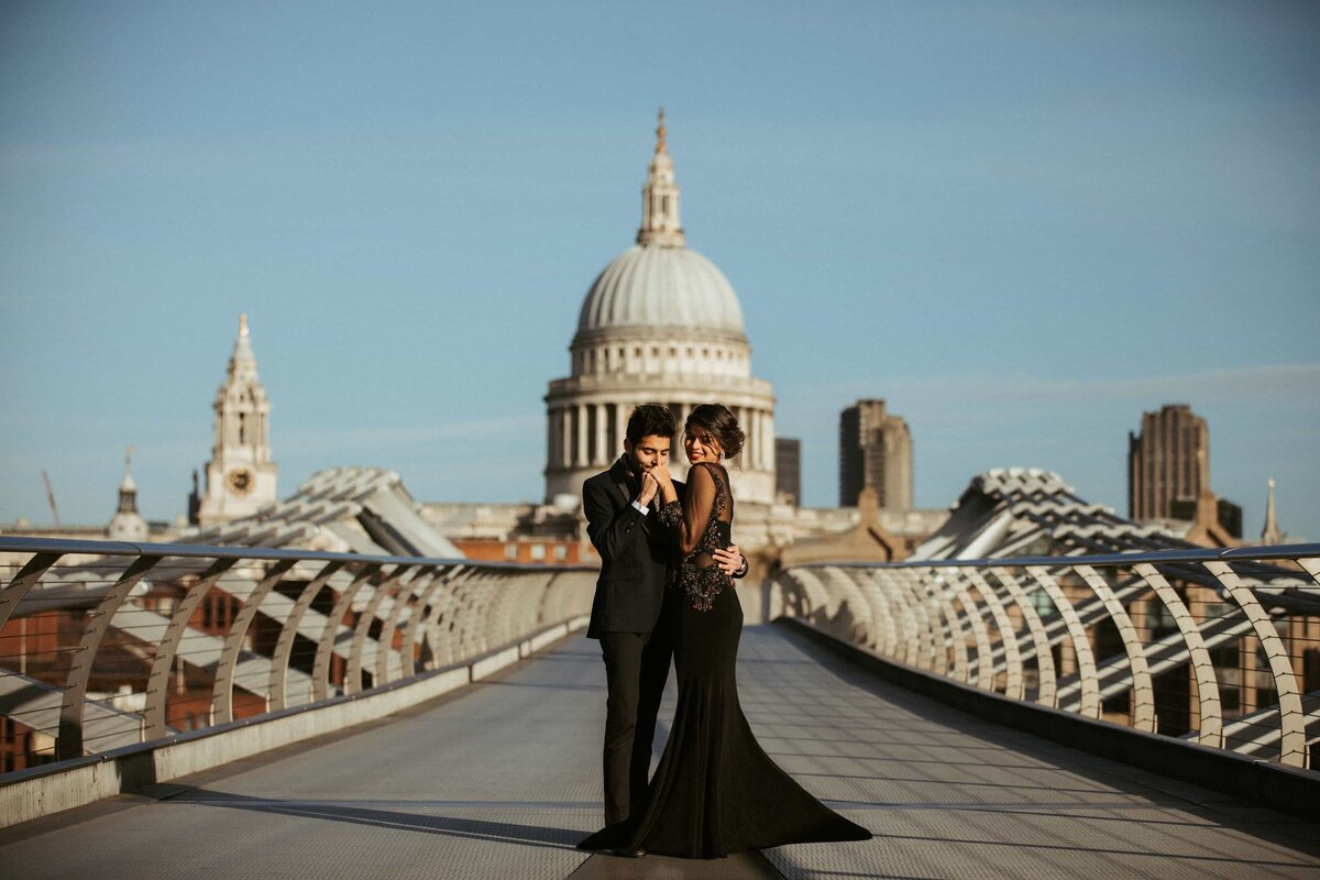 London couple photography indian bride and groom wearing black attire posing in front of St Paul's Cathedral for engagement photos