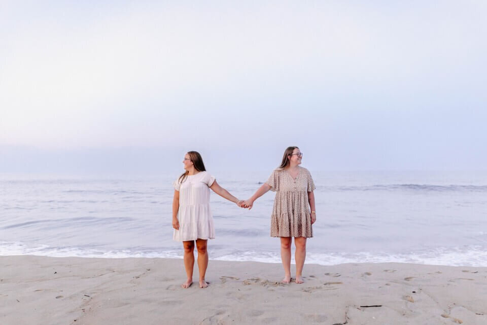 beautiful gay couple holding hands at sunset on cape henlopen beach delaware wedding photographer