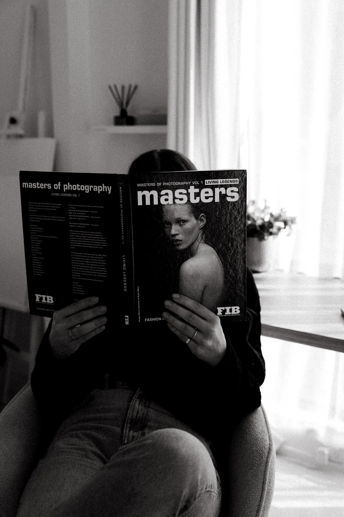 Black-and-white brand shot of a woman reading a photography magazine, taken by a Sunshine Coast branding photographer for modern creatives.
