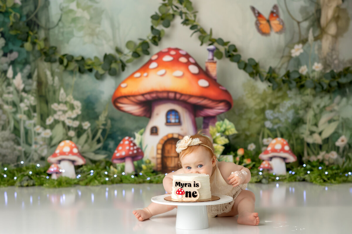 One year old Tampa baby enjoying a personalized luxury cake smash session with playful fairy garden decorations
