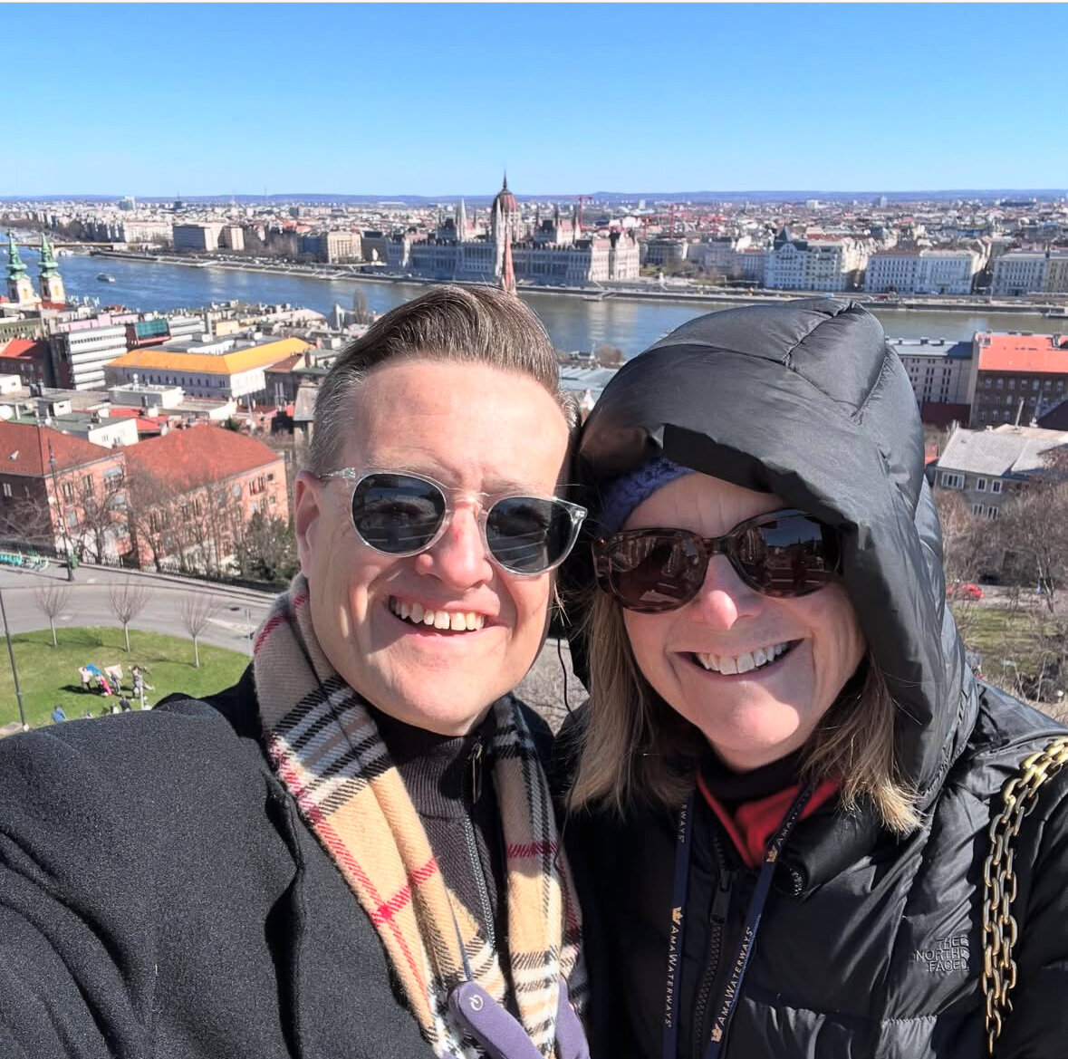 Jason and Kelly Smiling with the City Skyline behind them
