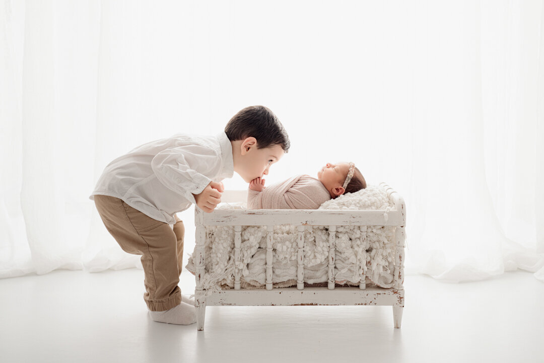 Grand Rapids Newborn Photography Brother Kissing Baby by For the Love of Photography