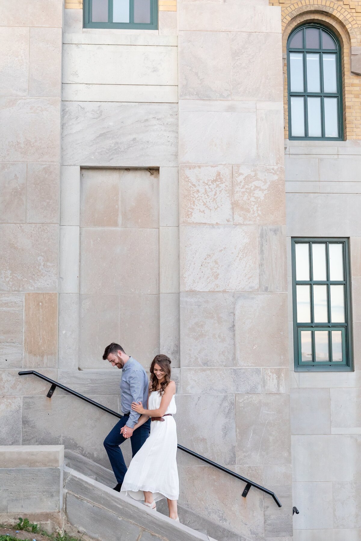 Couple-walks-up-the-stairs-holding-hands-at-RC-Harris-Water-Treatment-Plant-during-their-Toronto-engagement-session