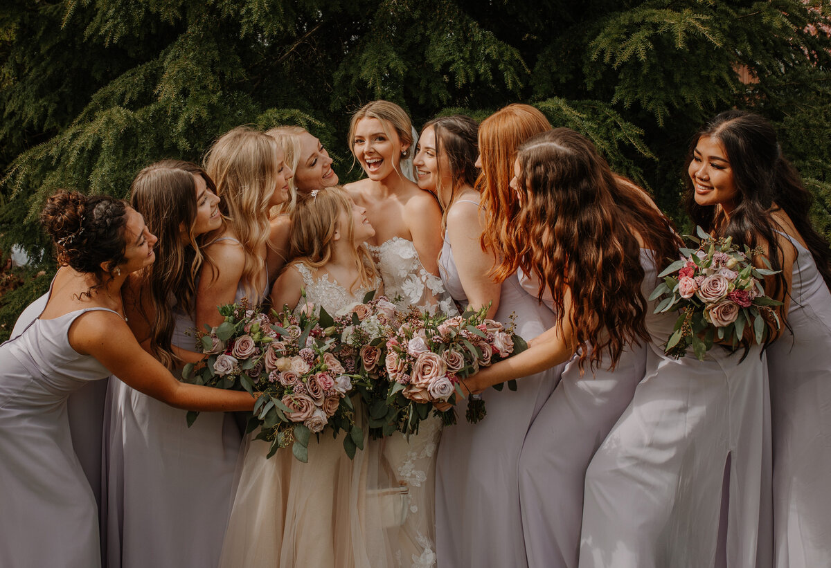 Group of bridesmaids hugging bride
