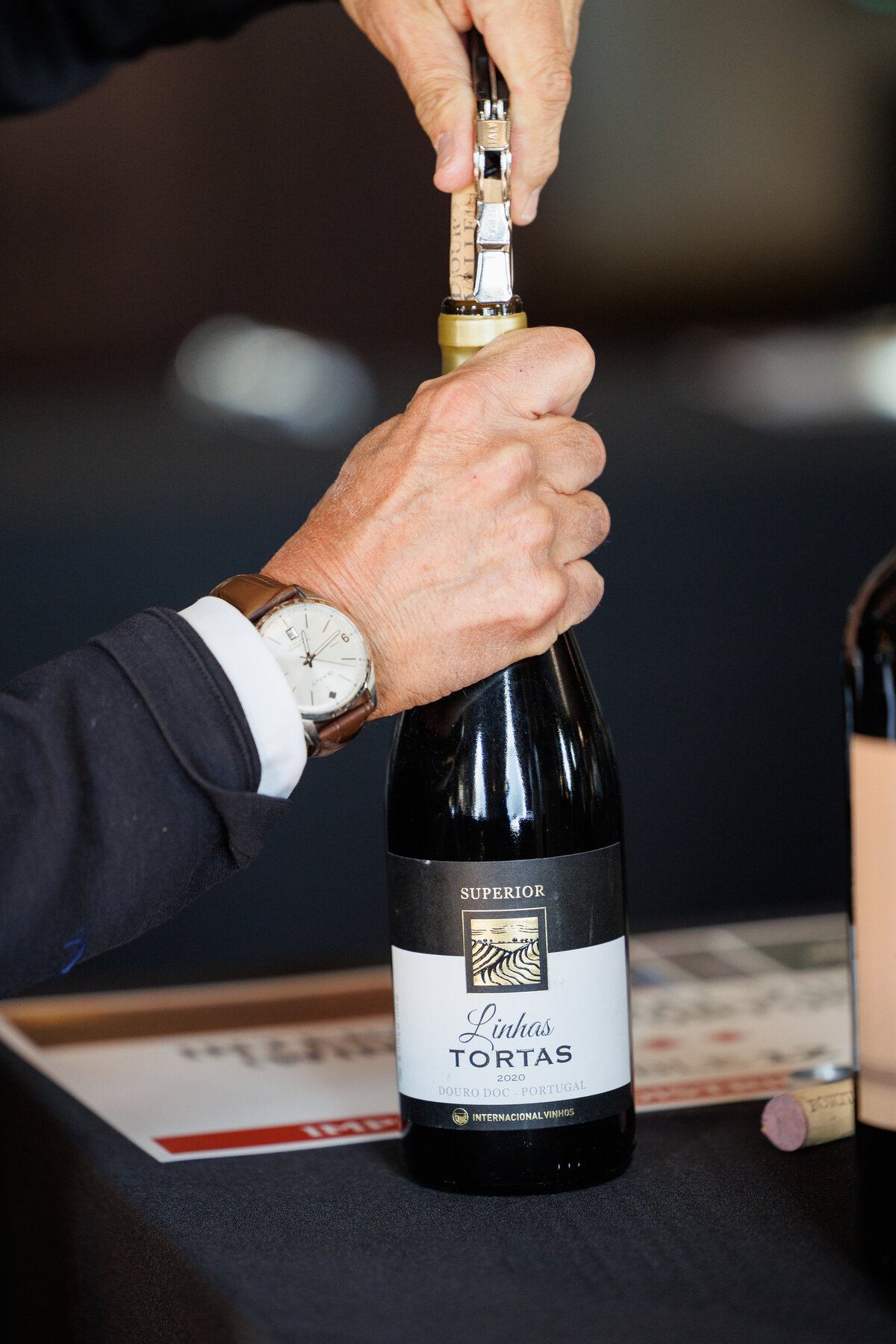 two hands opening a bottle of wine