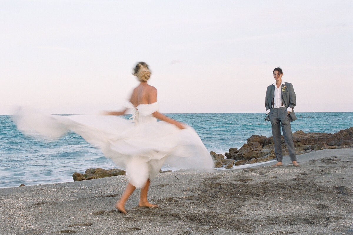 Bride rushes toward groom across the beach