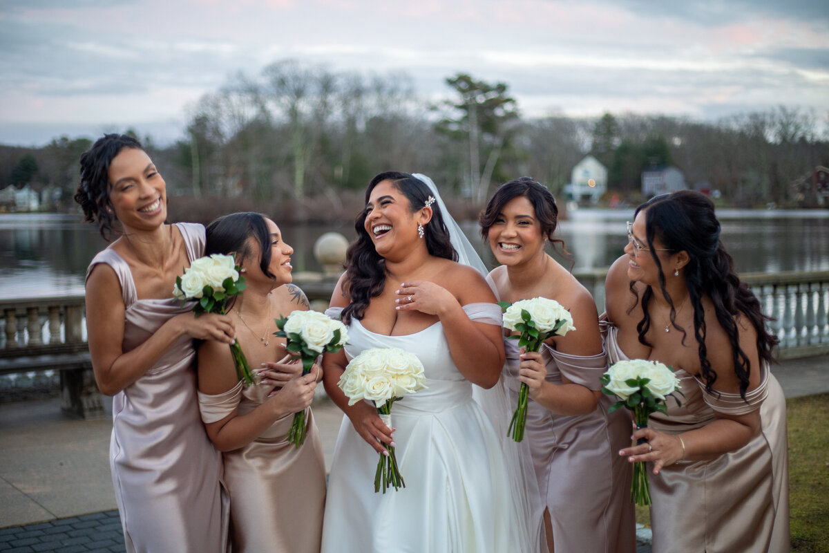 Bride laughing with her bridesmaids by her side