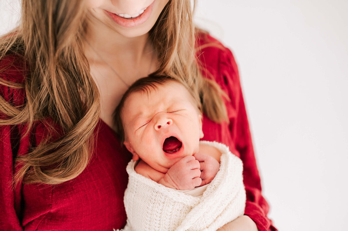 Springfield MO newborn photographer captures baby boy yawning on moms chest