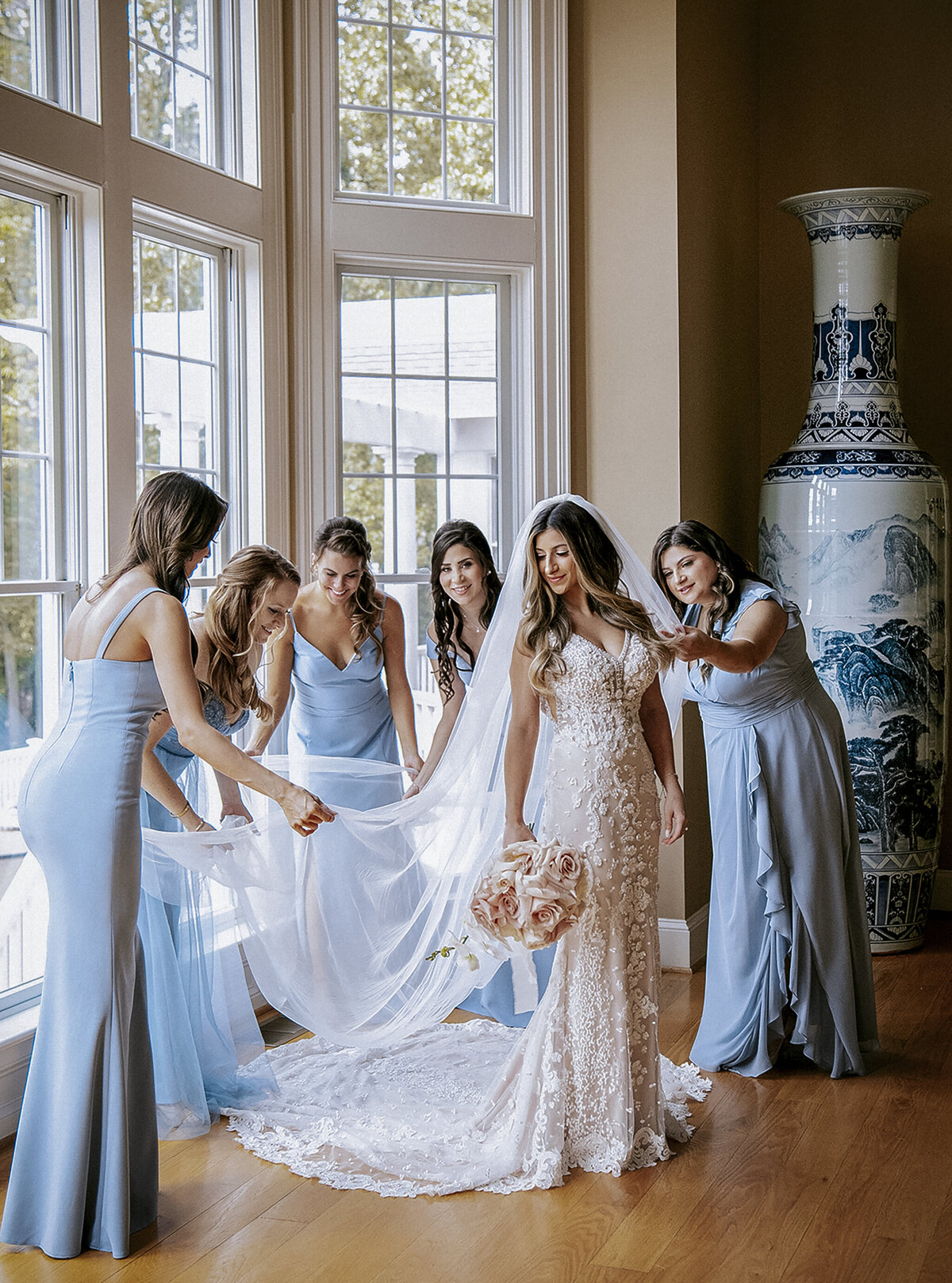 bridesmaids-in-blue-fluff-bridal-veil-at-window-before-wedding-ceremony