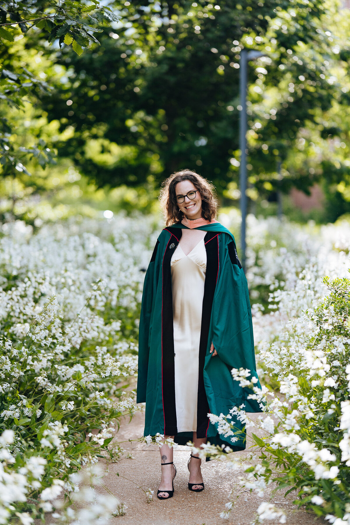 washu graduate standing in a patch of flowers on danforth campus