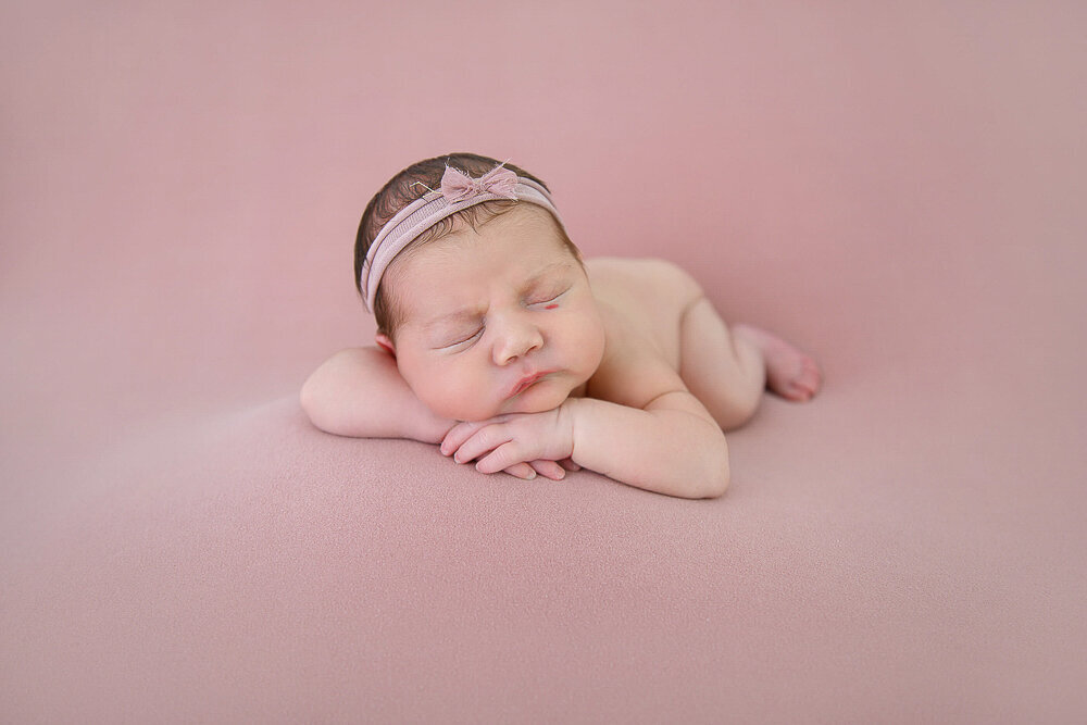 newborn girl on a pink background in Hamilton, Ontario.
