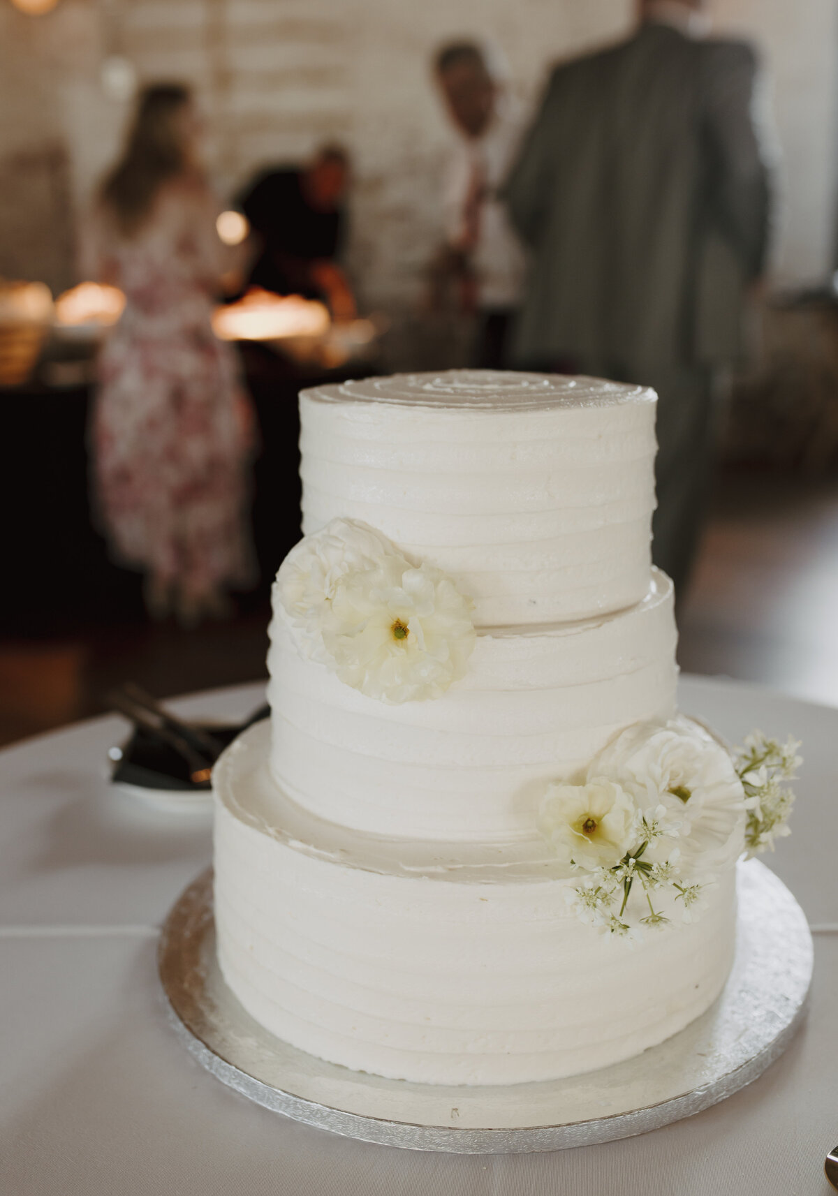 simple white wedding cake with white florals