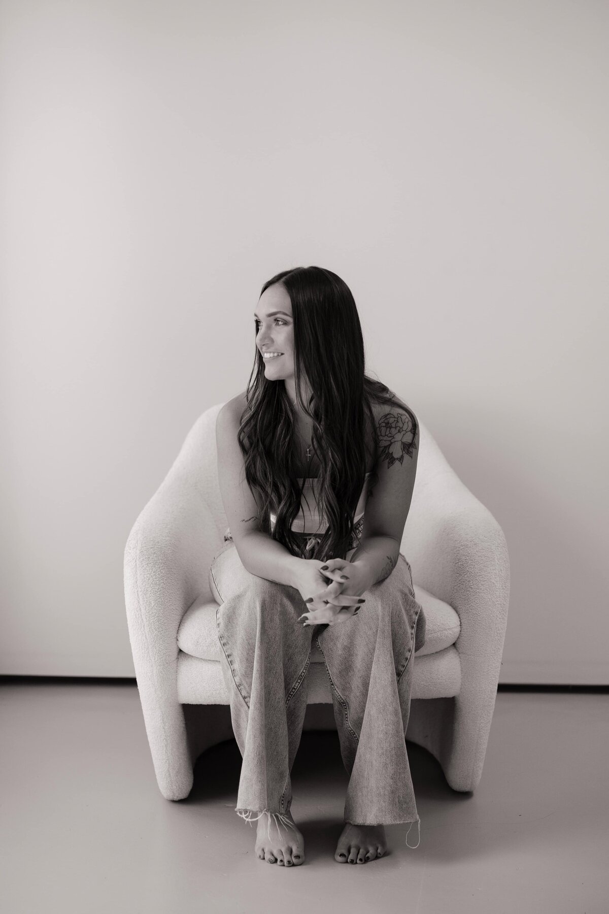 A fitness coach looks out a window while sitting in a chair.