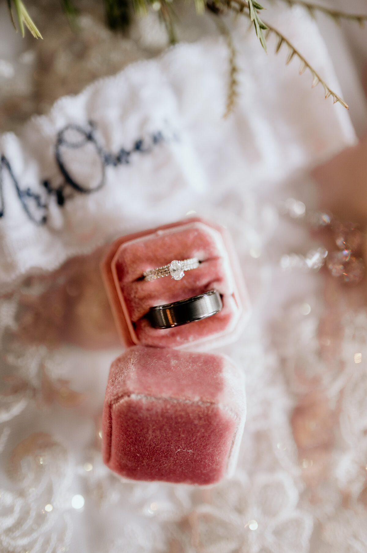 wedding detail shot of bride adn grooms wedding rings ina pink velvet box