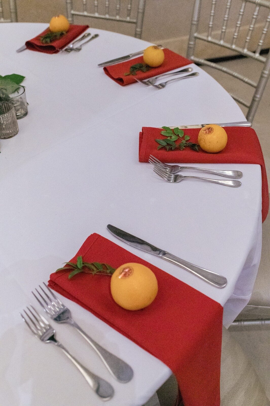 Chinese and Indian wedding fusion wedding tablescape, orange on top red napkin.