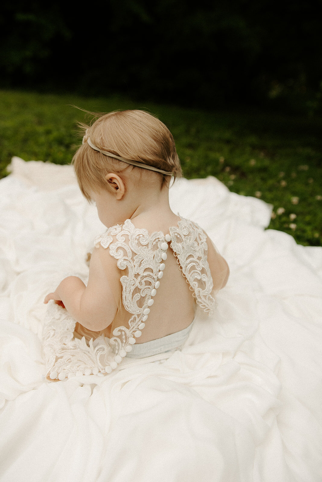daughter wearing mom's wedding dress for one year photoshoot at The Mill At Fine Creek