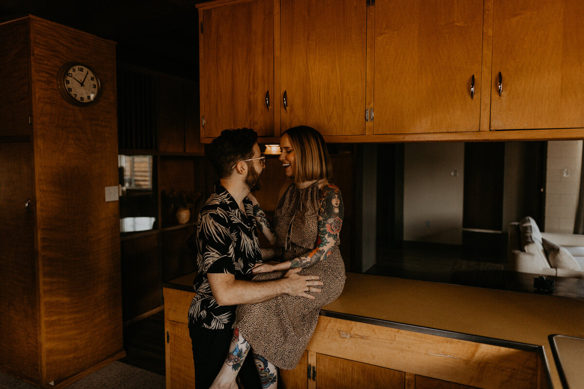 engaged couple hanging out in midcentury modern kitchen