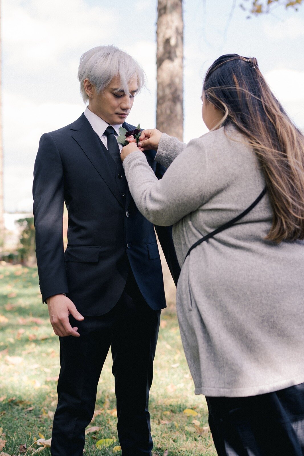 Girl helping the groom fix his suite