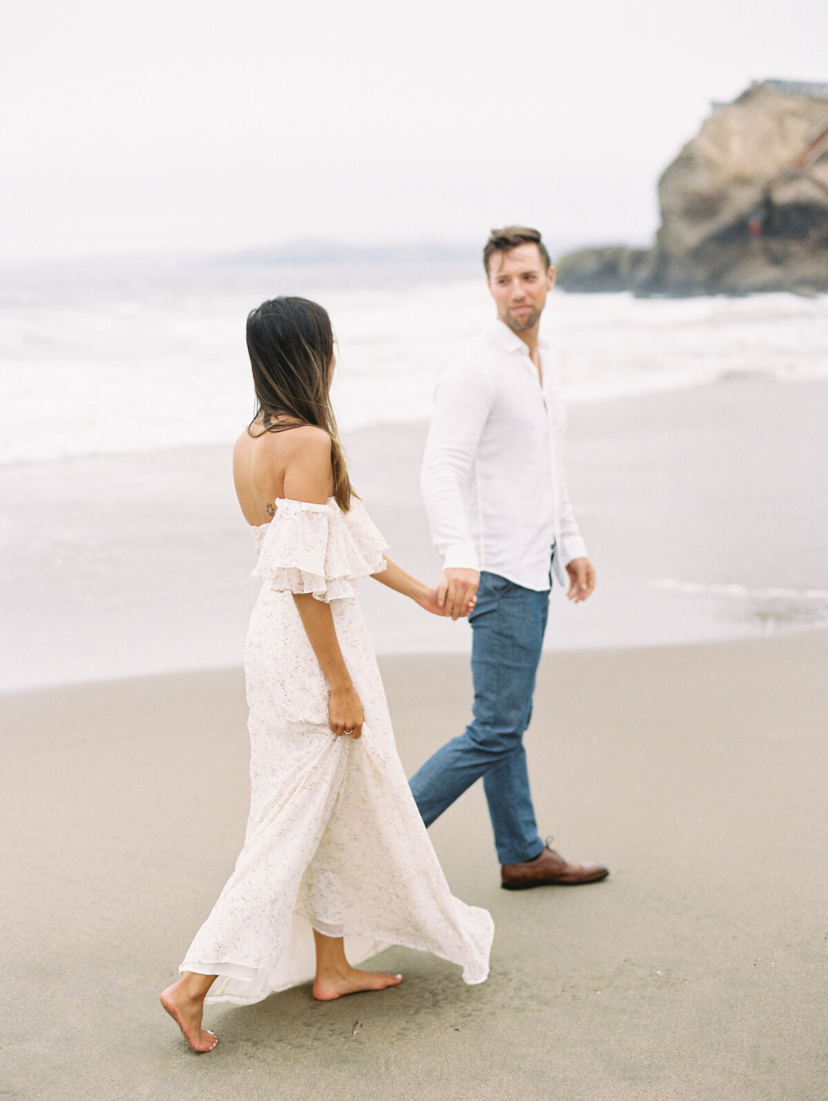 Bride and groom walking on beach photographed by Chicago editorial wedding photographer Arielle Peters