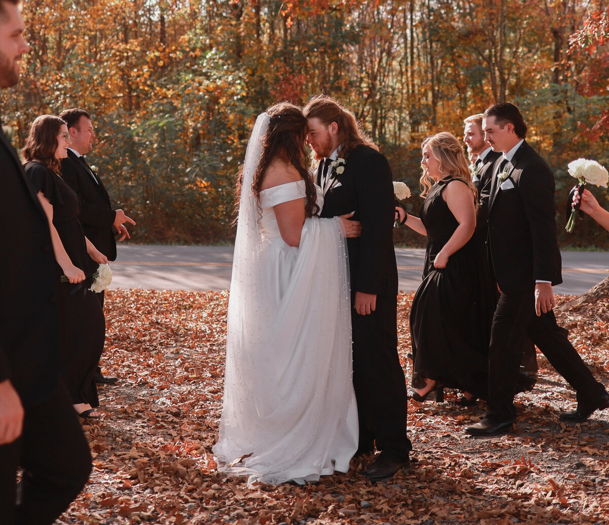 bride and groom kissing while bridal party walks by at Southern Charm wedding venue in Cleveland Tennessee by Nashville wedding photographer Amanda Richardson Photography