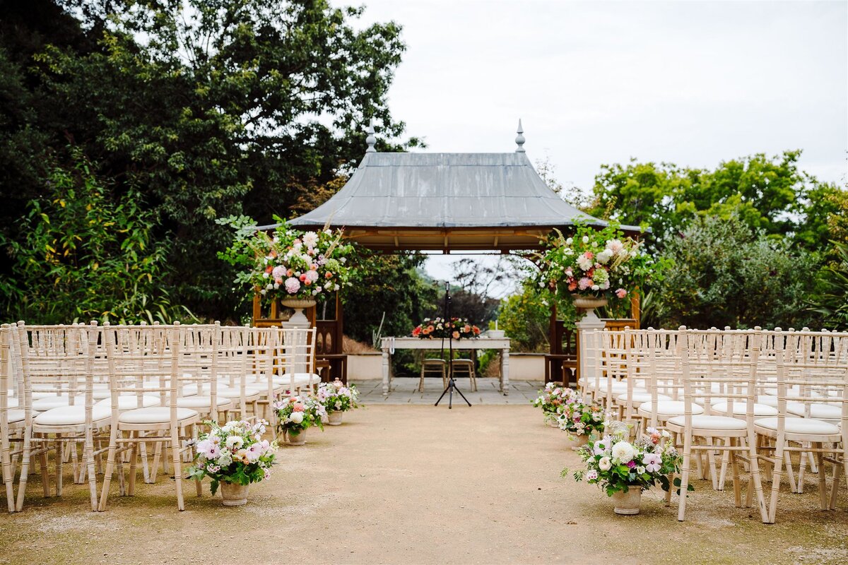 Outdoor garden ceremony, Clevedon Hall. Floral urns and meadow aisle 